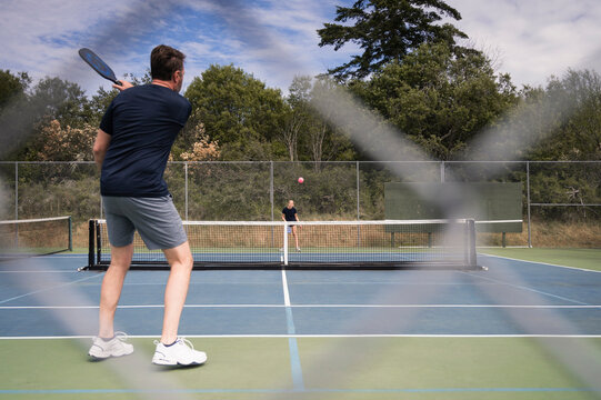 Two People Playing Pickleball on a Sunny Day