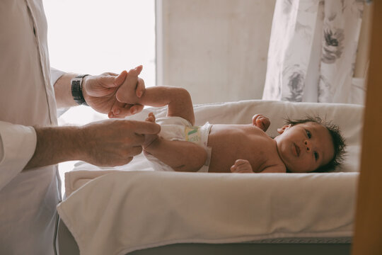 Dad holds the baby&rsquo;s legs