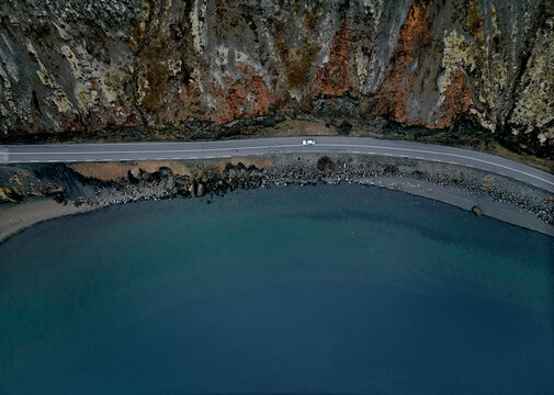 Blue lake with rocky cliff from drone