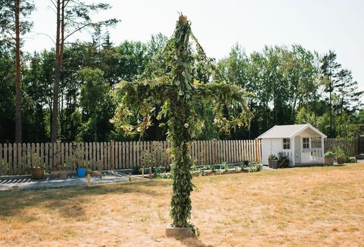 Homemade decorated Midsummer pole in a garden in Sweden