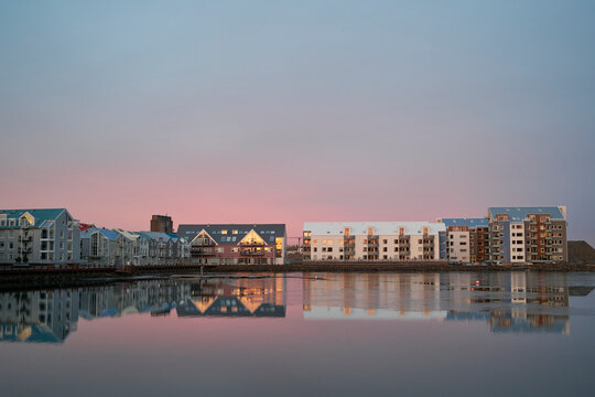 Modern residential district near calm river in evening