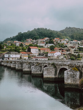 medieval stone bridge with village on background on Canimo de Santiago