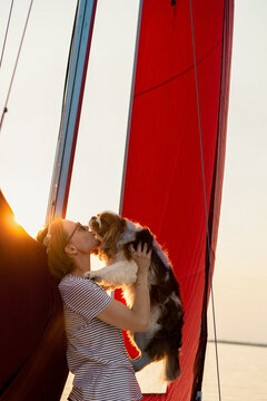 Young woman on a yacht with a dog, Cavalier King Charles Spaniel