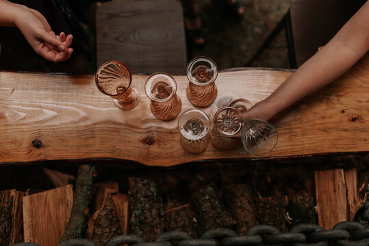 Overhead shot of two restaurant staff grabbing glasses from a slab bar