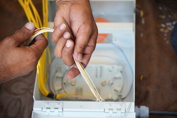 hands installing fiber cable Optical in junction box