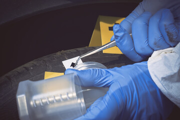 Crime scene investigation - collecting of evidences of soil samples on car wheel