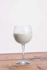glass goblet filled with milk on wooden rustic table