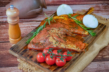 fresh iberian pork secret marinated with tomato, onion and rosemary, on a wooden board. - obrazy, fototapety, plakaty