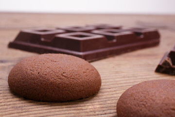 Obraz na płótnie Canvas Close-up chocolate cookies with dark chocolate squares on wooden table