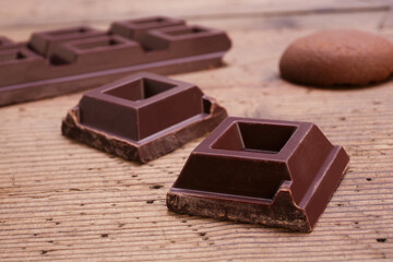 dark chocolate squares on rustic wooden table