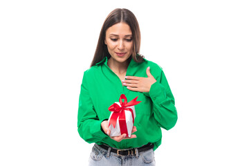 Fototapeta premium joyful well-groomed brunette long-haired young woman in a green shirt received a gift for her birthday on a white background with copy space