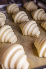 Fototapeta na wymiar Sheet of proofed croissant dough baking