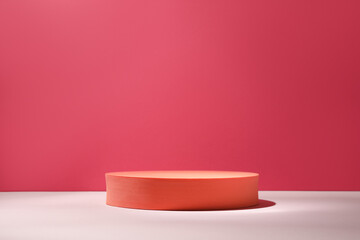 Orange stand on table against pink background, space for text. Stylish presentation for product