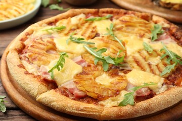 Delicious pineapple pizza with arugula on table, closeup