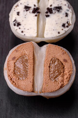 Delicious sweet mochi dessert with toppings on a dark concrete background