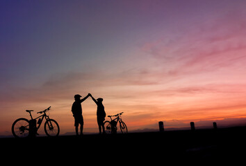 Fototapeta na wymiar Silhouette of cyclist stop watching the sunset
