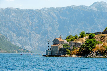 Ancient buildings on rocks in Montenegro, Adriatic sea view. Old town with orange roofs architecture and mountains landscapes