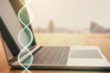 Double exposure of creative DNA hologram on laptop background. Bio Engineering and DNA Research...