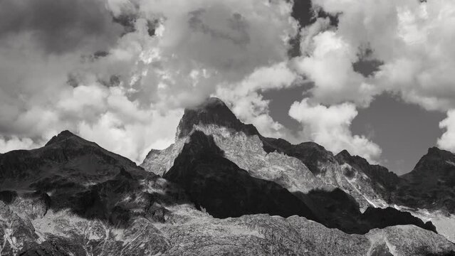 The Olan peak close-up in the Ecrins National Park with passing clouds (time-lapse in Black & White). Major peak of the GR54 Ecrins Massif hiking tour. Valgaudemar Valley, Hautes-Alpes, Alps, France