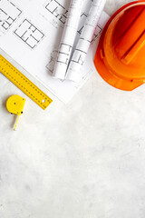 Top view of construction helmet on drawing blueprints for house designing and architect plan