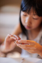 夏休みの家で手芸をやっている小学生の女の子の様子