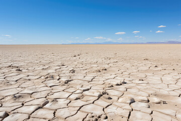 Driving through a desert road, with shimmering heatwaves, distant mirages, and the surreal beauty of the arid landscape stretching as far as the eye can see