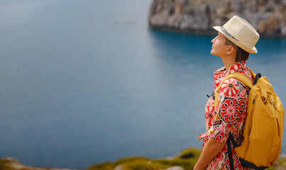 Asian woman in hat look on views of azure Bay in Mediterranean sea. Travel and vacation concept....
