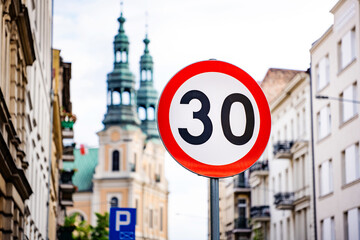 Car speed limit sign at street of old city center. Warning for traffic regulation - obrazy, fototapety, plakaty