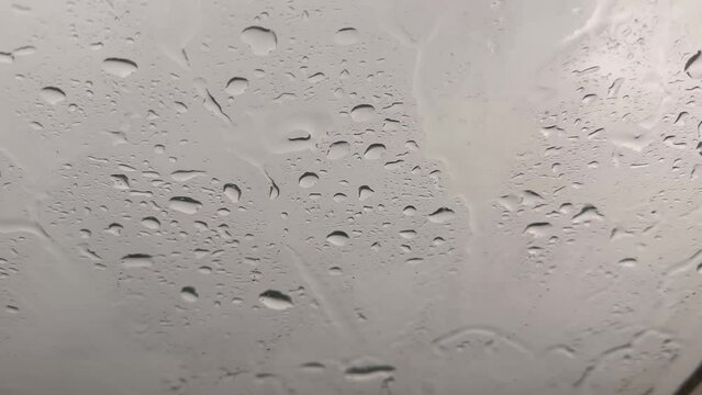 rain drops runnin down the window glass at rainy day. video 4k.