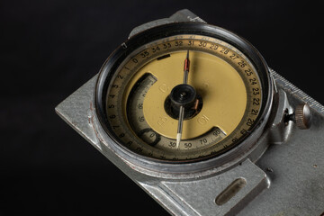 Old geological compass on dark background close up