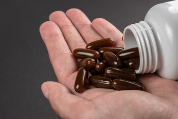 Lecithin gel pills capsule in the hand. Soy lecithin benefits for skin, digestion, lower cholesterol.