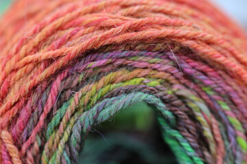 Closeup detail of a colourful skein of organic natural handspun and handdyed merino sheep wool,...