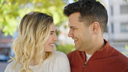 Fototapeta premium Man and woman couple smiling confident standing together at park