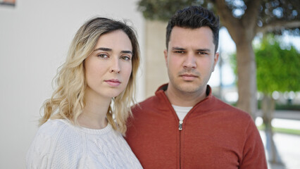 Obraz premium Man and woman couple standing together with relaxed expression at street