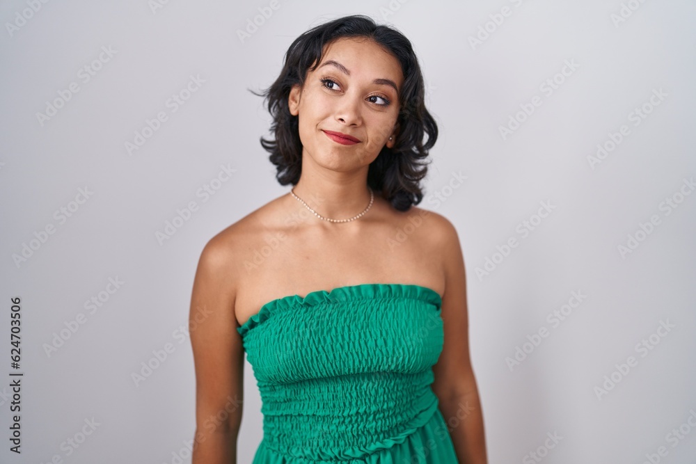 Canvas Prints Young hispanic woman standing over isolated background smiling looking to the side and staring away thinking.