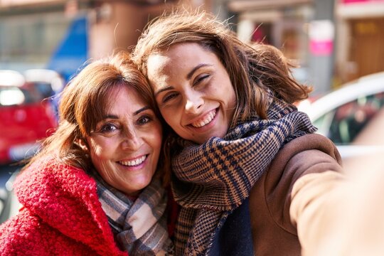 Two women mother and daughter make selfie by camera at street
