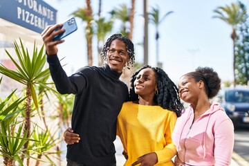 African american friends standing together making selfie by the smartphone at street