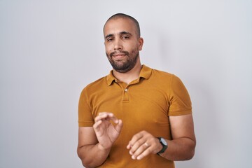 Hispanic man with beard standing over white background disgusted expression, displeased and fearful...