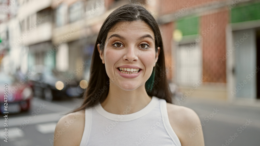 Wall mural Young beautiful hispanic woman smiling confident standing at street