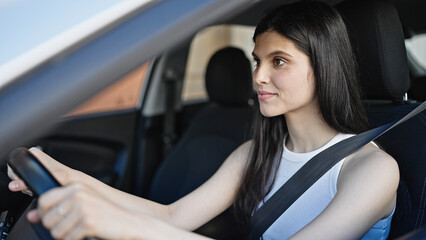 Fototapeta na wymiar Young beautiful hispanic woman smiling confident driving car at street