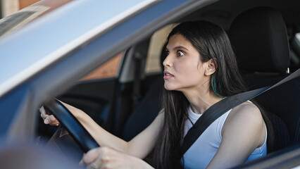 Obraz na płótnie Canvas Young beautiful hispanic woman stressed driving car at street