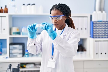 African american woman scientist holding sample at laboratory