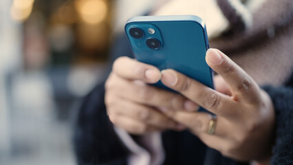 Young african american woman using smartphone at street