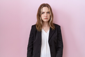 Young caucasian business woman wearing black jacket skeptic and nervous, frowning upset because of problem. negative person.