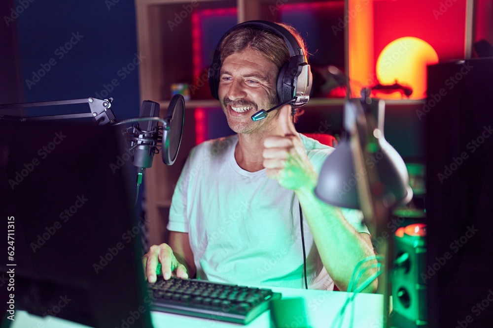 Sticker caucasian man with mustache playing video games smiling happy and positive, thumb up doing excellent