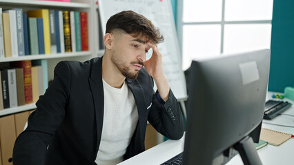 Young arab man student using computer studying at university classroom