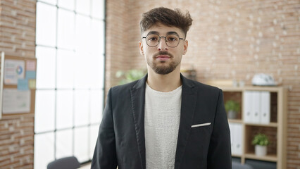 Young arab man business worker standing with relaxed expression at office