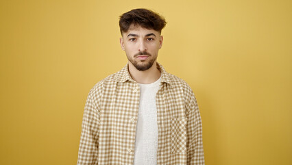 Young arab man standing with relaxed expression over isolated yellow background