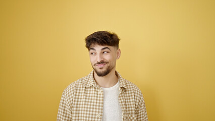 Young arab man smiling confident standing over isolated yellow background