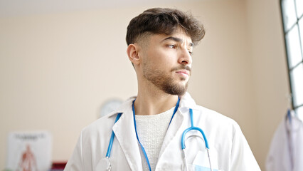 Young arab man doctor standing with relaxed expression at clinic